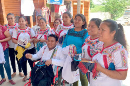Mujeres de comunidades mostrando su trabajo de bordado artesanal